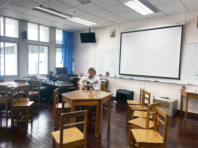 Enthusiastic music teacher in classroom setting in Bangkok
